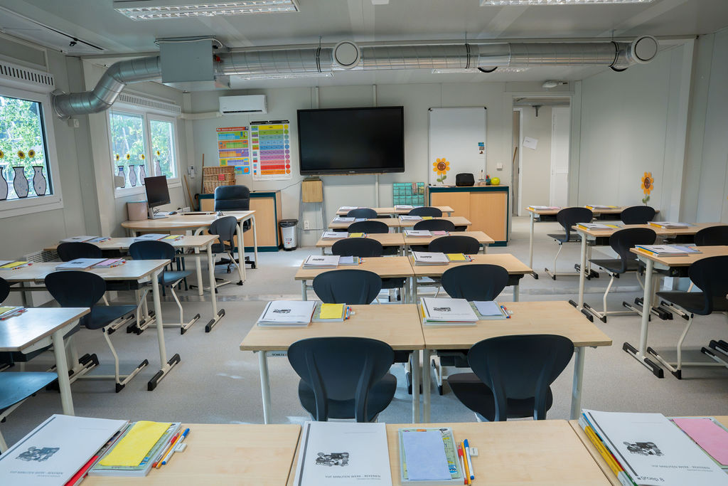 Innenansicht eines hellen Klassenzimmers im modularen Schulgebäude von Idelco