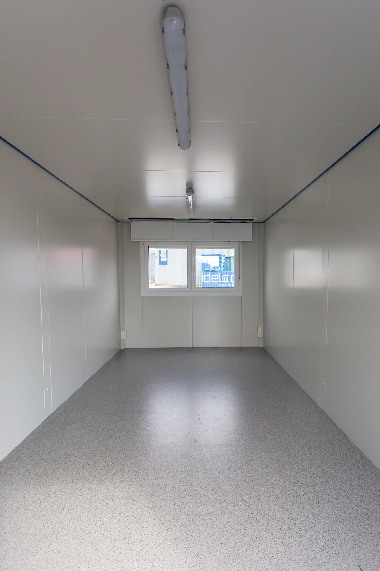 Interieur van een modulaire unit met afgewerkte modulaire wandpanelen, plafond en vloer.