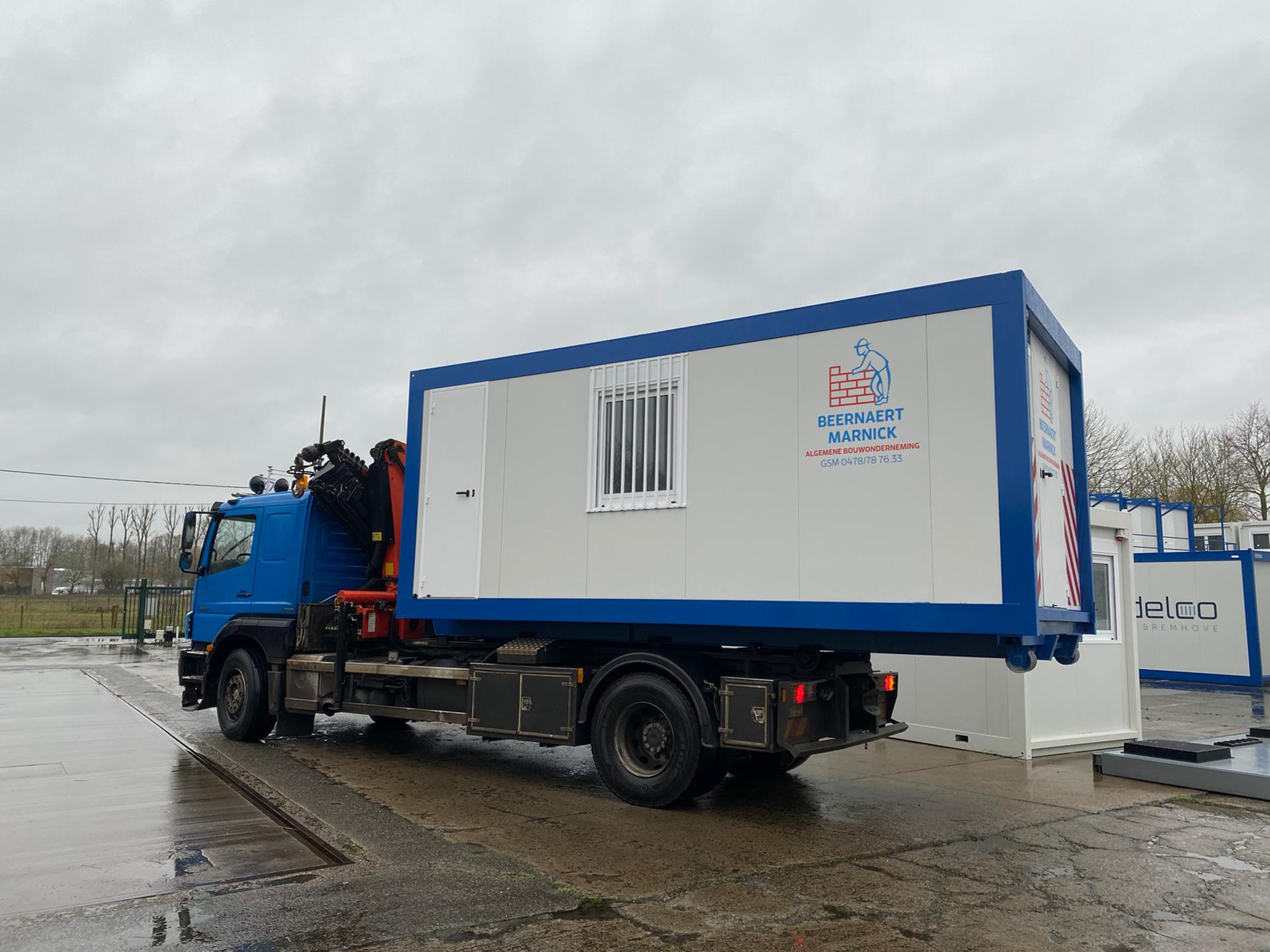 Robust blue Idelco portable site office with corporate branding at a project location
